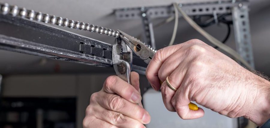 Tools are used to work on a garage door opener chain